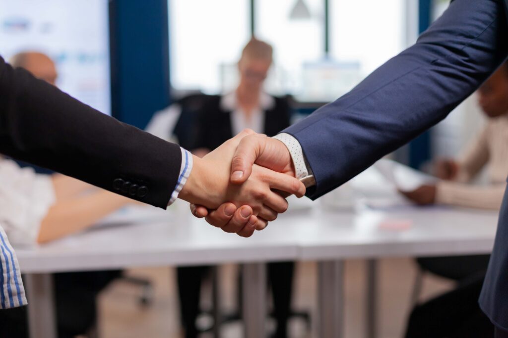 Satisfied businessman company employer wearing suit handshake new employee